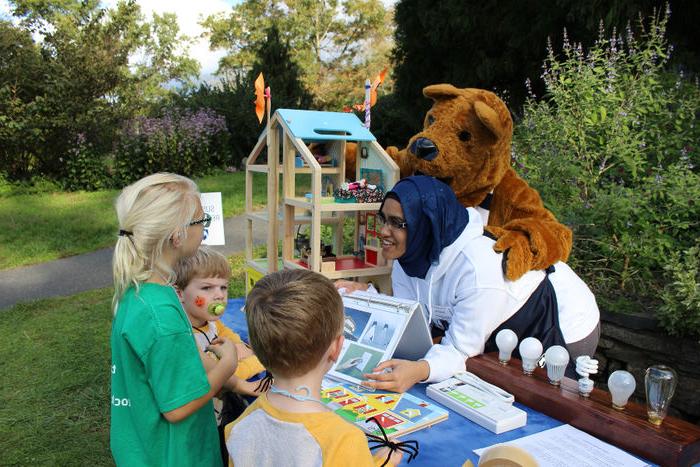 Student and Lion mascot teaching children.